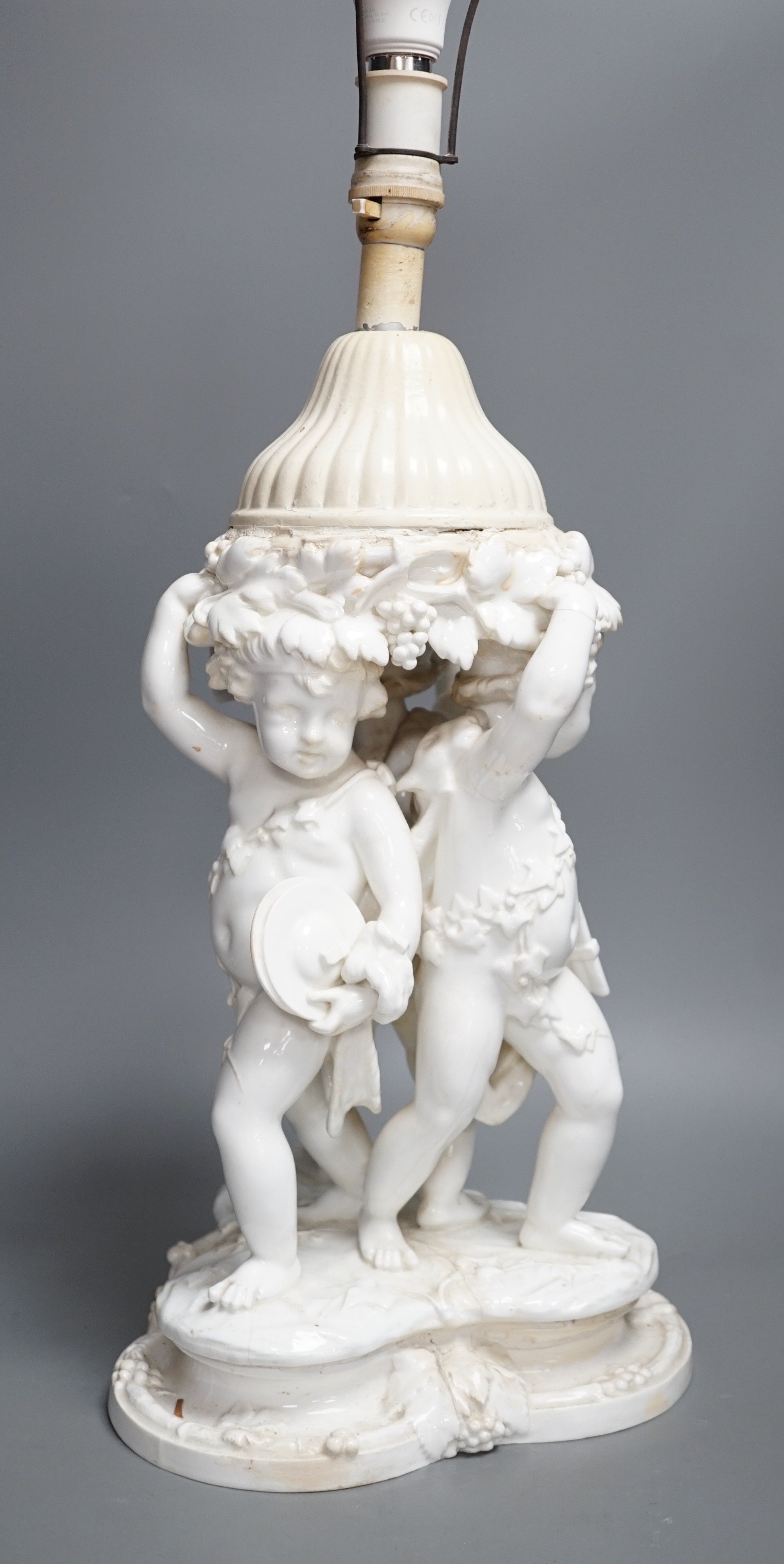 A Victorian English porcelain cherub centrepiece, now mounted as a lamp (restored), possibly Moore Bros., 71 cm height to top of lamp fitting